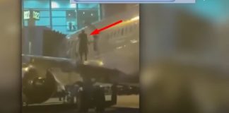 Hombre abre la puerta de emergencia de un avión y sale al ala de la aeronave mientras sale de la pista de aterrizaje